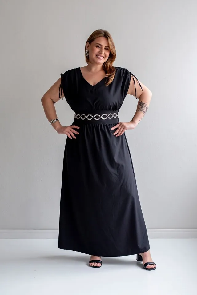 Plus size model wearing a long black dress with a belt