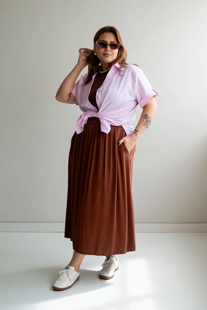 Plus size model wearing a lilac shirt and a brown midi skirt